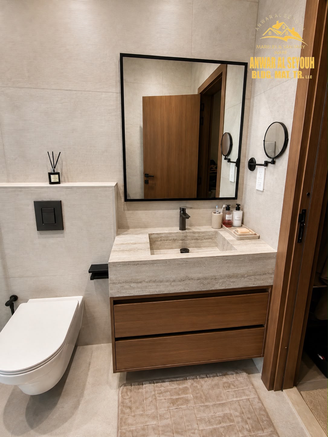 Travertine vanity counter with an integrated basin, two wooden drawers and a black framed mirror