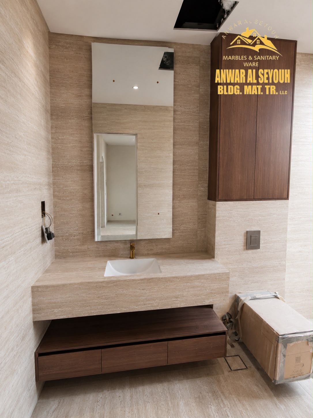 Travertine vanity with a gold tap, a wall-mounted wooden cabinet and a three-drawer unit beneath
